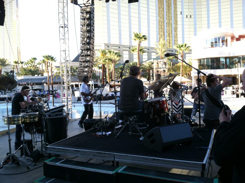 view of concert from back stage behind drummer with Mandalay Bay hotel in the background